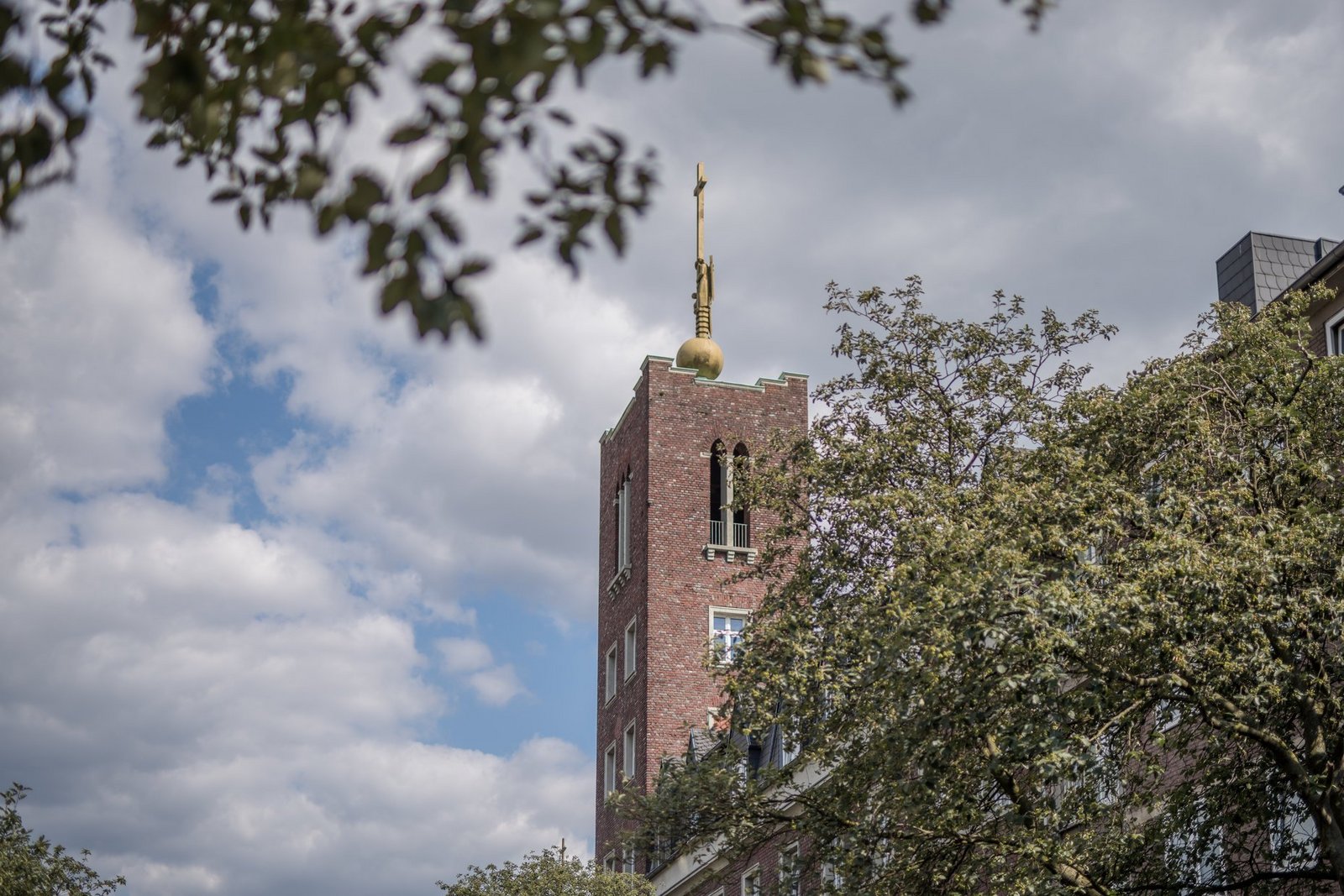 Der Turm der St. Alexius-Kapelle ragt in den Himmel über dem Haupteingang am zentralen Standort der Alexianer am Alexianergraben in Aachen