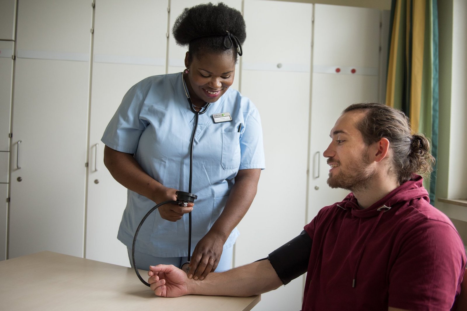 Gesundheits- und Krankenpflegerin misst den Blutdruck